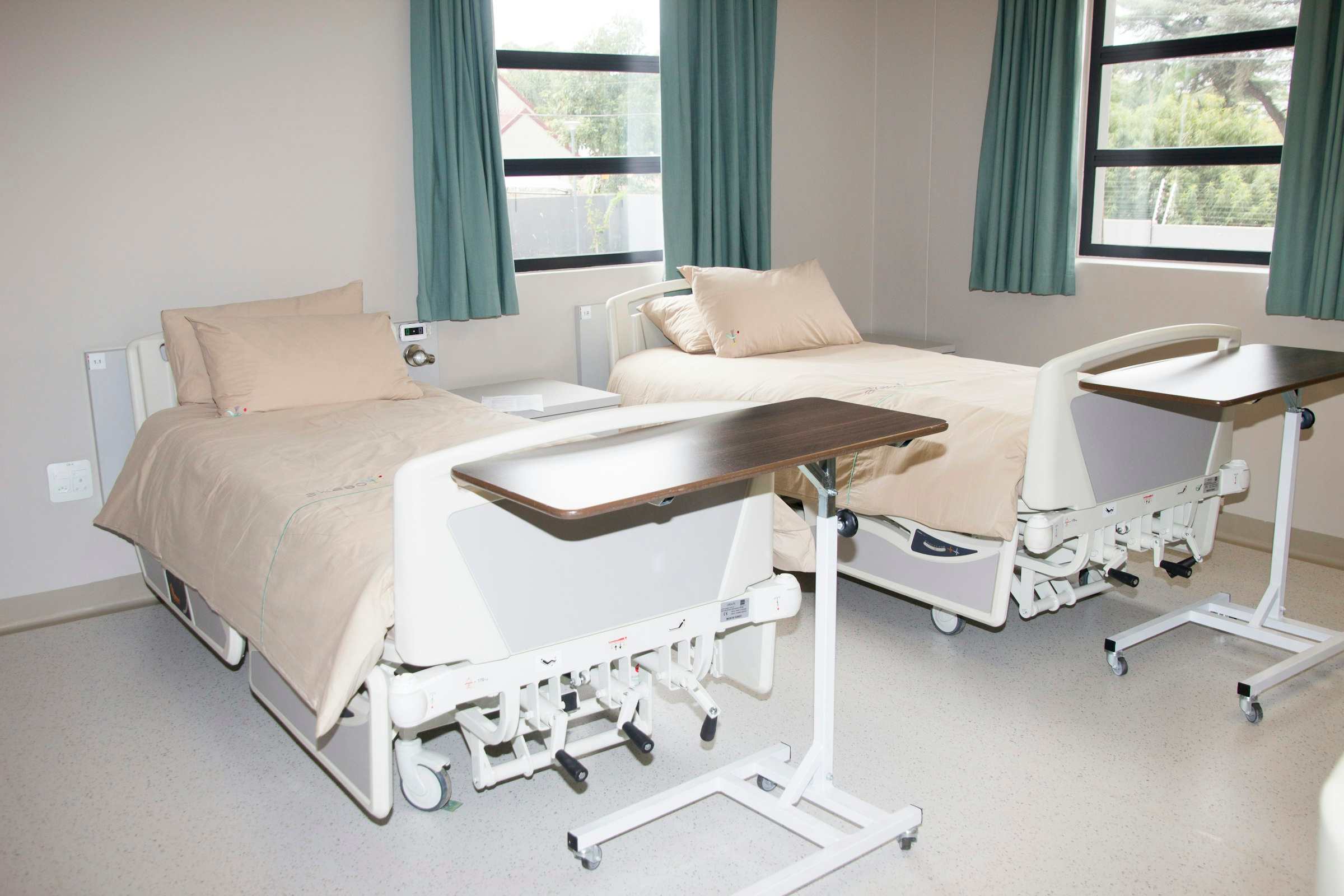 A clinic treatment room with the bed, side cabinet and blind fitted