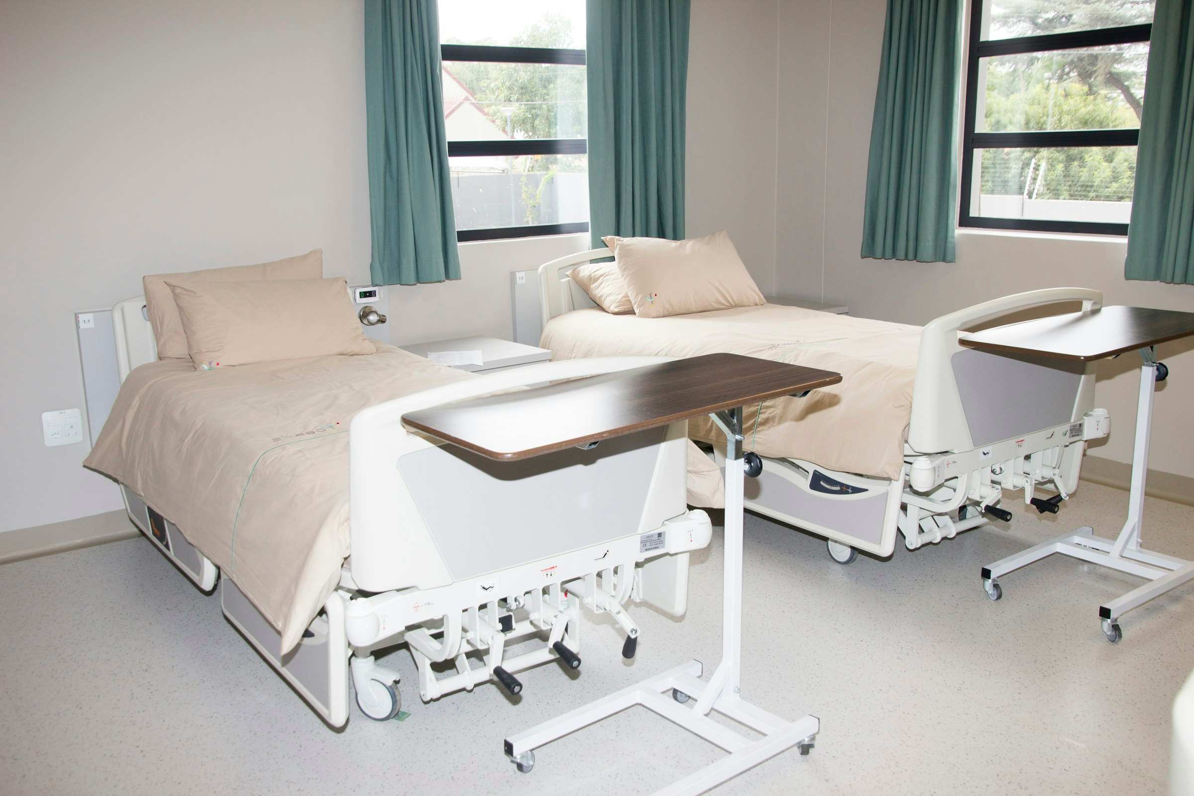 A clinic treatment room with the bed, side cabinet and blind fitted